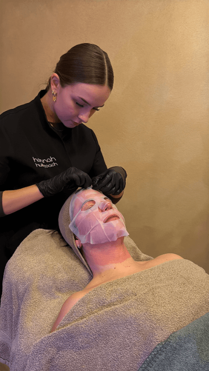 Huidcoach legt sheet masker op gezicht van cliënte na SkinPen microneedling behandeling